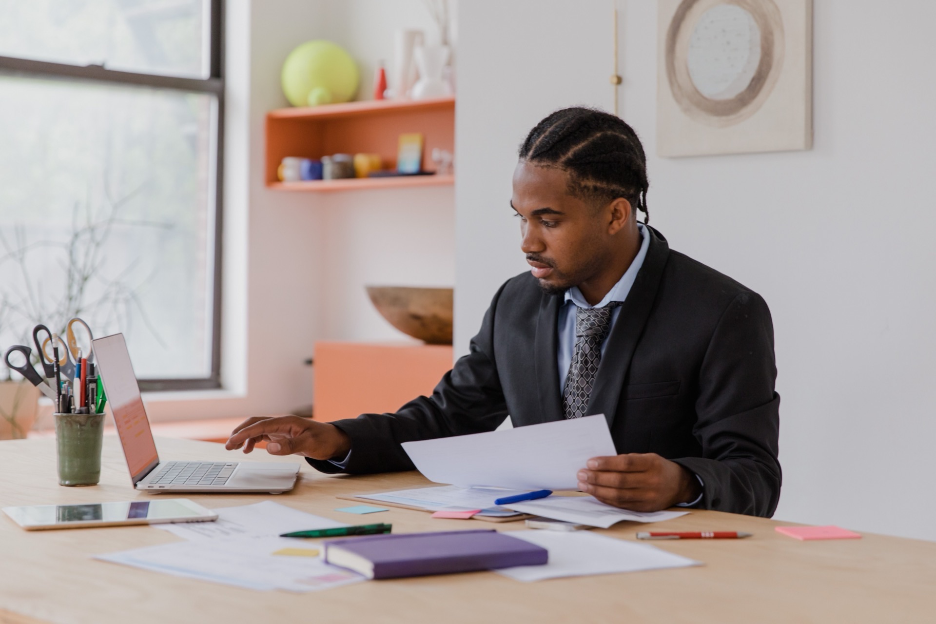 Entrepreneur and loan officer reviewing documentation at desk with organized folder